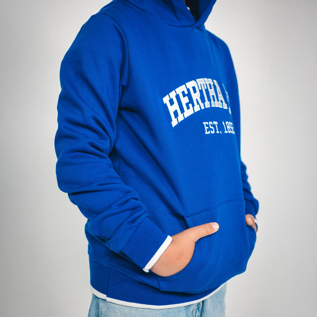 Hertha Hoodie College Blau Kids Detail Seitenansicht mit Hände in Bauchtasche