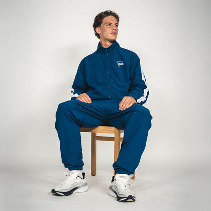 Hertha Jacke Nylon Trainingsanzug mit Soufian Gouram sitzend auf einem Stuhl