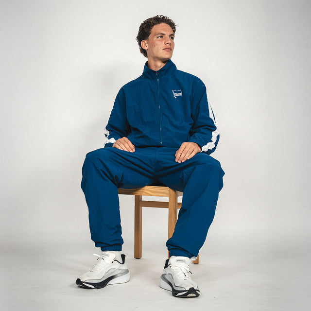 Hertha Jacke Nylon Trainingsanzug mit Soufian Gouram sitzend auf einem Stuhl