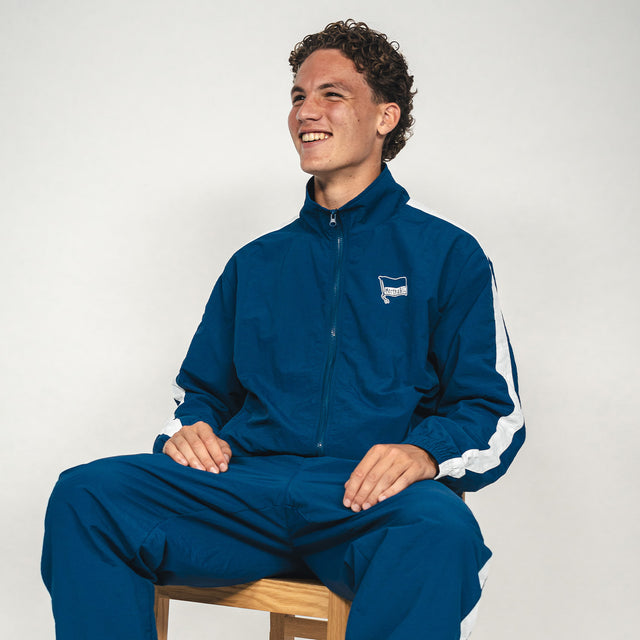 Hertha Jacke Nylon Trainingsanzug mit Soufian Gouram auf dem Stuhl