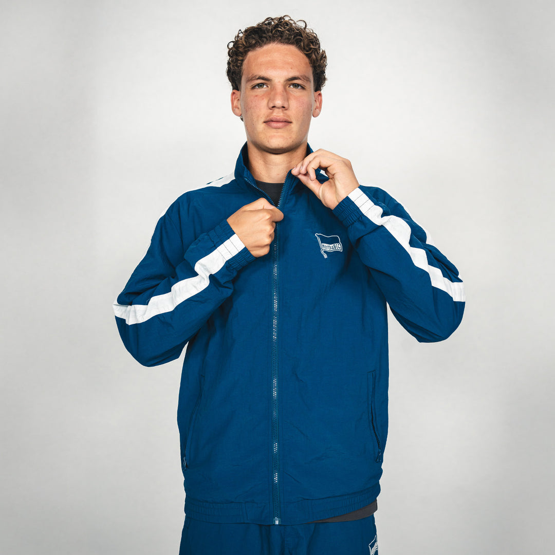 Hertha Jacke Nylon Trainingsanzug Vorderansicht Hand am Zipper